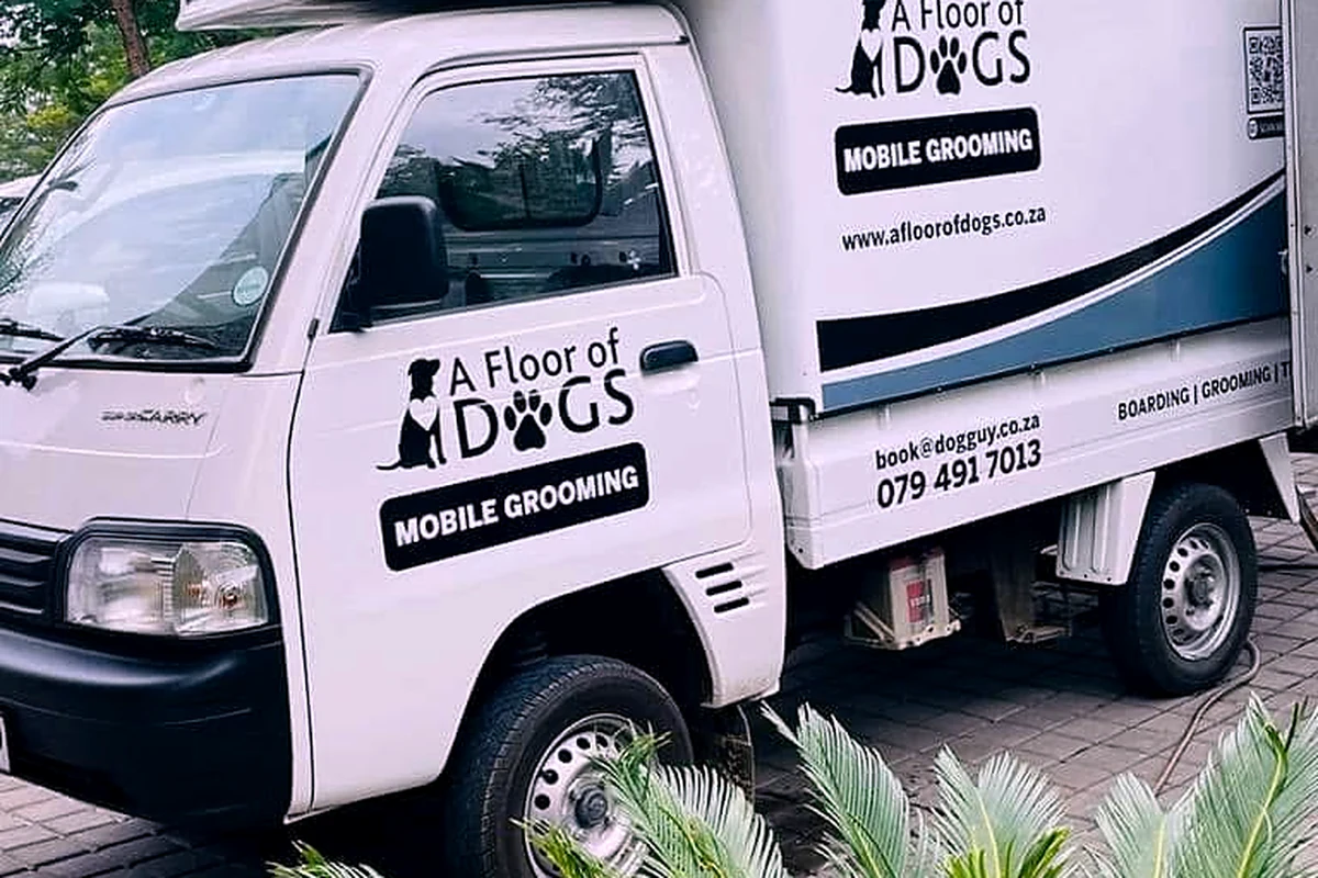 A Floor of Dogs grooming van with historic signage