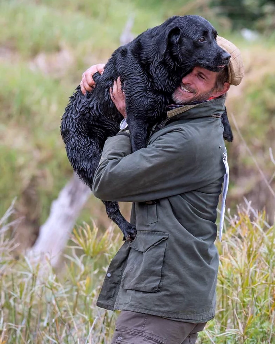 Gareth smiling with a dog in a close portrait